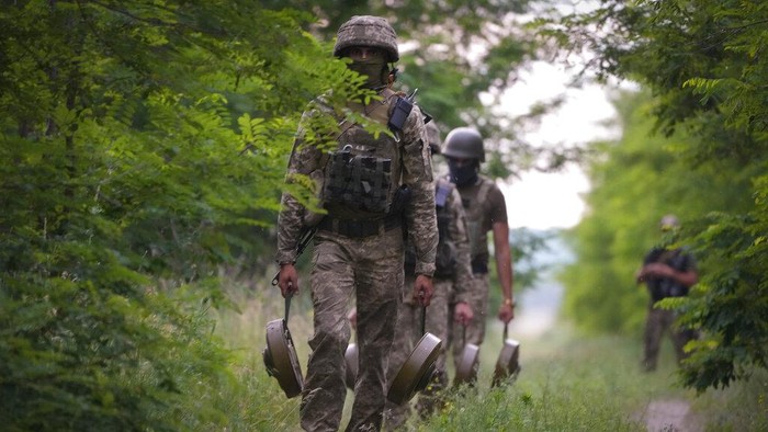 Potret Tentara Ukraina Tebar Ranjau Anti-tank di Jalan Hutan A soldier of Ukraine's special operations unit lays a Germany-donated DM22 directional anti-tank mine on a forest road on the Russian troops' potential way in the Donetsk region, Ukraine, late Tuesday, June 14, 2022.(AP Photo/Efrem Lukatsky)