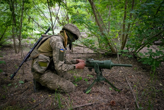 A soldier of Ukraines special operations unit lays a Germany-donated DM22 directional anti-tank mine on a forest road on the Russian troops potential way in the Donetsk region, Ukraine, late Tuesday, June 14, 2022.(AP Photo/Efrem Lukatsky)