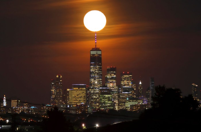 Purnama Stroberi di New York JERSEY CITY, NJ - JUNE 14: The full Strawberry Supermoon rises behind lower Manhattan and One World Trade Center in New York City on June 14, 2022, as seen from Jersey City, New Jersey. (Photo by Gary Hershorn/Getty Images)