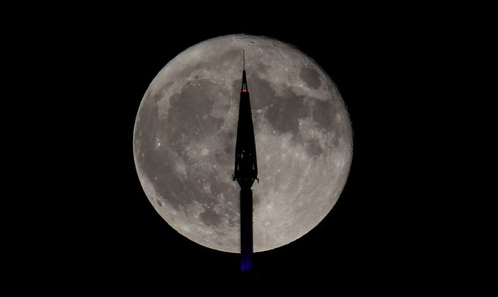 JERSEY CITY, NJ - JUNE 14: The full Strawberry Supermoon rises behind lower Manhattan and One World Trade Center in New York City on June 14, 2022, as seen from Jersey City, New Jersey.  (Photo by Gary Hershorn/Getty Images)