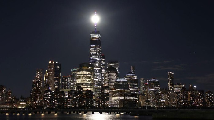 JERSEY CITY, NJ - JUNE 14: The full Strawberry Supermoon rises behind lower Manhattan and One World Trade Center in New York City on June 14, 2022, as seen from Jersey City, New Jersey.  (Photo by Gary Hershorn/Getty Images)