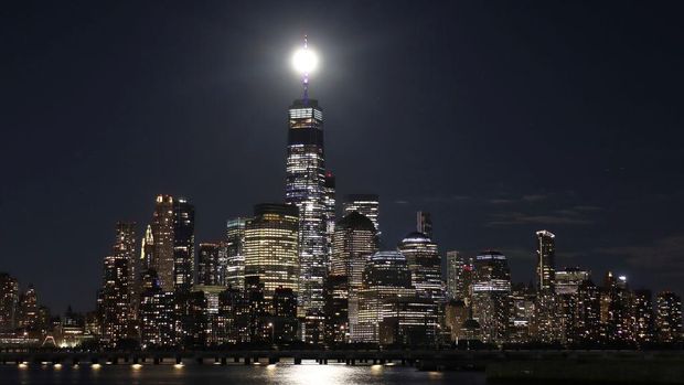 JERSEY CITY, NJ - JUNE 14: The full Strawberry Supermoon rises behind lower Manhattan and One World Trade Center in New York City on June 14, 2022, as seen from Jersey City, New Jersey.  (Photo by Gary Hershorn/Getty Images)