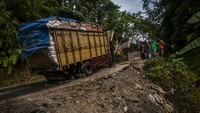 Sebuah truk mengalami gangguan mesin di sebuah jalan yang amblas di Cikulur, Lebak, Banten, Selasa (14/6/2022).