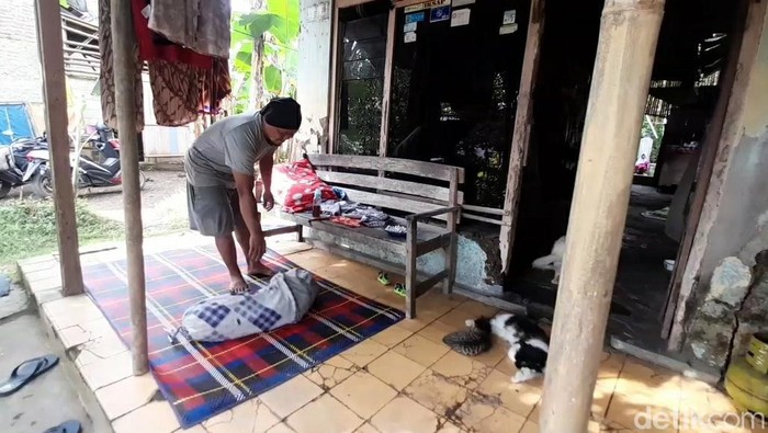 Warga Brebes, Akhmad Amin Lutfi (34) menyiapkan tempat untu tidur di emperan rumahnya, Rabu (15/6/2022). Dia terpaksa tidur di emperan karena rumahnya rusak parah gegara lapuk.