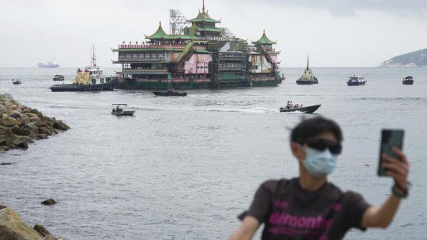 Hong Kong's iconic Jumbo Floating Restaurant is towed away in Hong Kong, Tuesday, June 14, 2022. Hong Kong's iconic restaurant on Tuesday departed the city, after its parent company failed to find a new owner and lacked funds to maintain the establishment amid months of COVID-19 restrictions. (AP Photo/Kin Cheung)