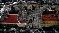 Penampakan sebuah trem yang tertimpa reruntuhan bangunan usai ledakan menghancurkan depot trem di kawasan Kharkiv, Ukraina, Rabu (15/6/2022) waktu setempat.
