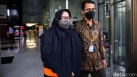 Ade Yasin tampak mengenakan kerudung berwarna hitam dan rompi oranye KPK saat hendak meninggalkan gedung KPK.