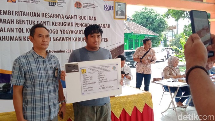Gibran (berkaus abu) menerima plakat UGR proyek jalan tol Jogja-Solo, Kamis (16/6/2022).