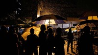 Mereka tetap nekat antre meski hujan mengguyur kawasan Departemen Imigrasi dan Emigrasi Sri Lanka.