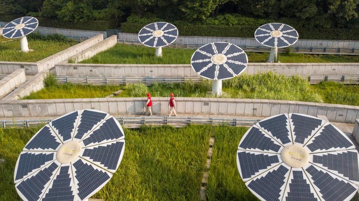 ZHENJIANG, CHINA - JUNE 16, 2022 - Power workers inspect photovoltaic power generation facilities at Binjiang Park in Yangzhong City, Zhenjiang city, East China's Jiangsu Province, June 16, 2022. Binjiang Park is the first zero-carbon park in Jiangsu province with a variety of solar photovoltaic installations. The park covers an area of 1100 mu. From the rechargeable photovoltaic seats to the landscape lamp, and then to the pavilion with its own power generation, the whole zero-energy consumption park is composed of photovoltaic + energy storage renewable energy system. (Photo credit should read CFOTO/Future Publishing via Getty Images)
