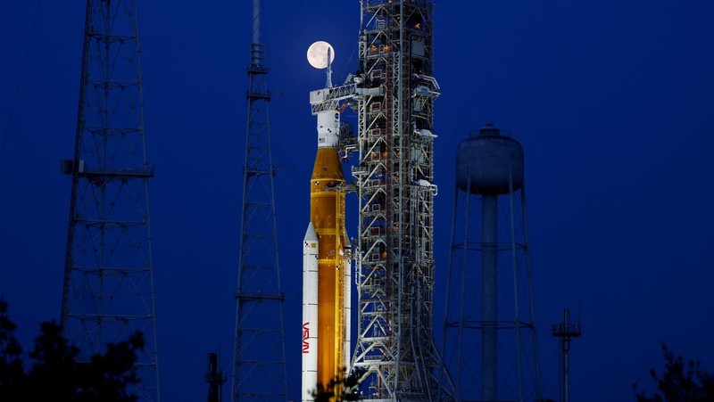 Bulan purnama stroberi terlihat di langit AS. Pemandangan tak biasa pun terlihat kala roket NASA untuk misi ke bulan terpotret bersama purnama stroberi.