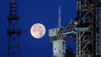 Bulan purnama stroberi terlihat di langit AS. Pemandangan tak biasa pun terlihat kala roket NASA untuk misi ke bulan terpotret bersama purnama stroberi.