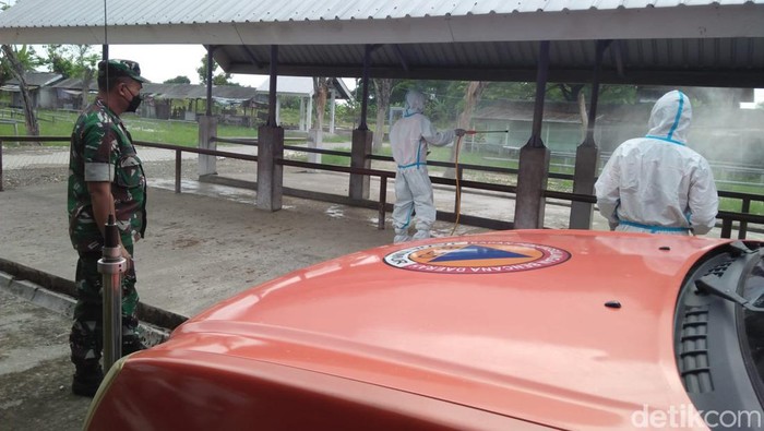 Petugas saat menyemprot kandang ternak dengan disinfektan