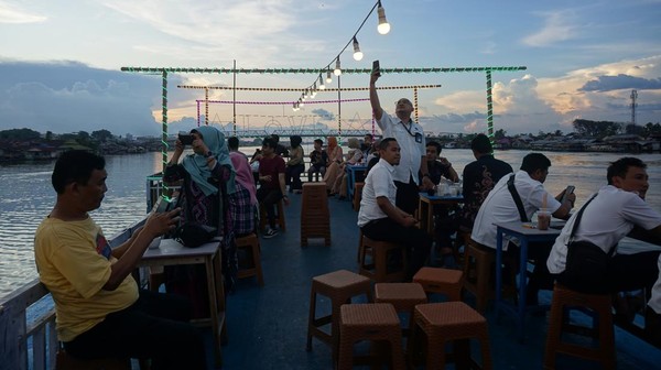 Sejumlah penumpang kapal wisata menikmati pemandangan saat menyusuri Sungai Kapuas di Pontianak, Kalimantan Barat, Rabu (15/6/2022).