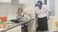 Salah seorang pegawai Warpopski tampak tengah bersiap di sebuah dapur. Ia menggunakan celemek dan topi berlogo Warpopski.