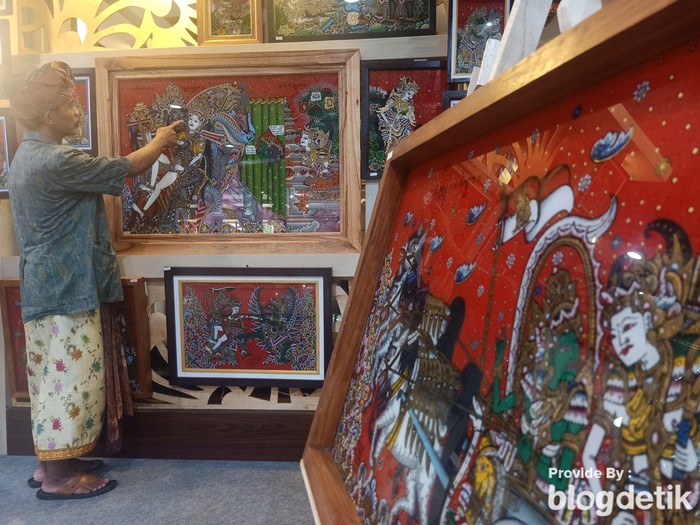 Pelukis kaca, I Ketut Santosa ketika menunjukkan lukisan kaca Nagasepaha yang bernilai Rp 6 juta di Art Center Denpasar pada Jumat (17/6/2022)