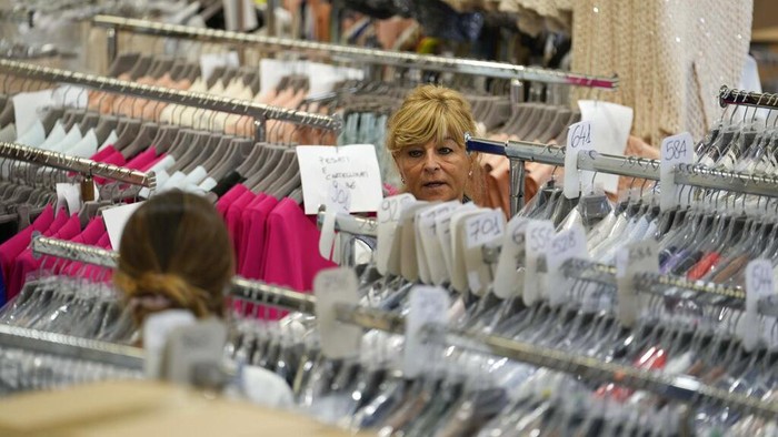 Sanksi Rusia Bikin UMKM di Italia Kebanjiran Order, Begini Kesibukannya Nadia Zanola, chairman of the Cose di Maglia and owner of the D. Exterior brand, goes through racks of clothing at a warehouse section of unsold clothes, in Brescia, Italy, Tuesday, June 14, 2022. Small Italian fashion producers are still allowed to export to Russia, despite sanctions, as long as the wholesale price is under 300 euros. But they are having a hard time getting paid, due to restrictions tied to the financial sector. (AP Photo/Luca Bruno)