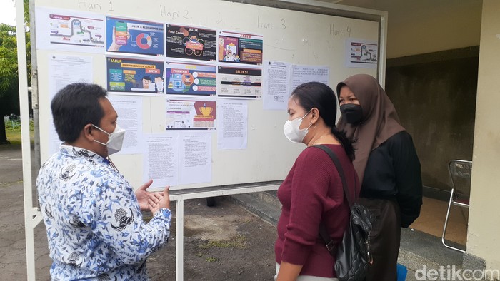 Seorang guru di SMA 1 Semarang memberikan penjelasan mengenai PPDB kepada orang tua calon murid, Jumat (17/6/2022).