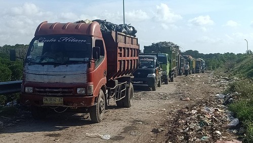 Beberapa supir truk sampah tampak tengah mengobrol sembari menunggu antrian di TPA Suwung pada Jumat (17/6/2022).