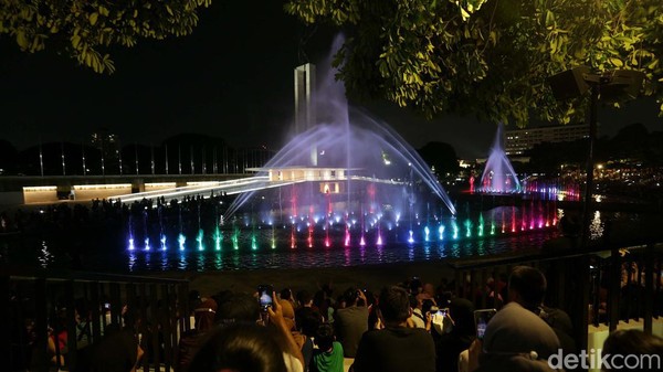 Warga menyaksikan pertunjukan air mancur di Taman Lapangan Banteng, Jakarta Pusat, Sabtu (18/6/2022).