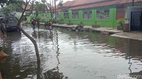 Genangan banjir rob menggenangi jalan permukiman warga. Genangan banjir rob juga masuk ke rumah warga yang berada di tepi Sungai Wiso.
