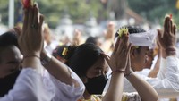 Orang-orang membawa sesaji untuk berdoa selama festival keagamaan Kuningan.