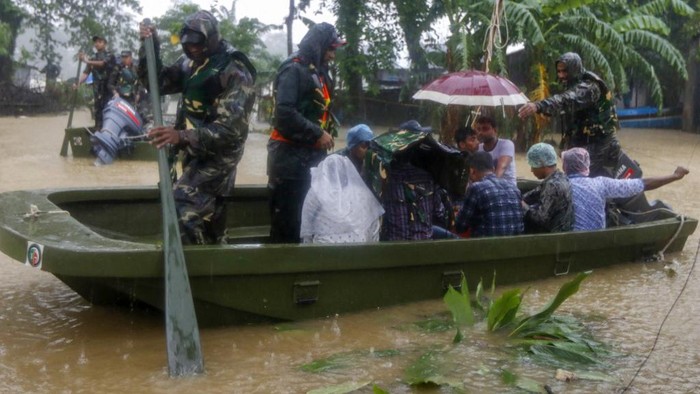 Bangladesh army personnel evacuate affected people from a flooded area following heavy monsoon rainfalls in Sylhet on June 18, 2022. - Monsoon storms in Bangladesh have killed at least 25 people and unleashed devastating floods that left more than four million others stranded, officials said Saturday. (Photo by AFP)