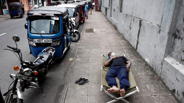 Potret 'Gabut' saat Antre BBM di Sri Lanka A schoolboy studies while waiting in a queue with his father to buy petrol due to fuel shortage, amid the country's economic crisis, in Colombo, Sri Lanka, June 16, 2022. REUTERS/Dinuka Liyanawatte