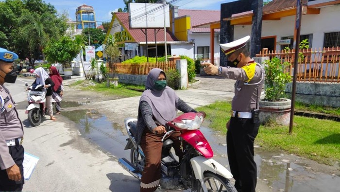 Seorang wanita kedapatan berkendara tanpa memakai helm.(foto: istimewa)