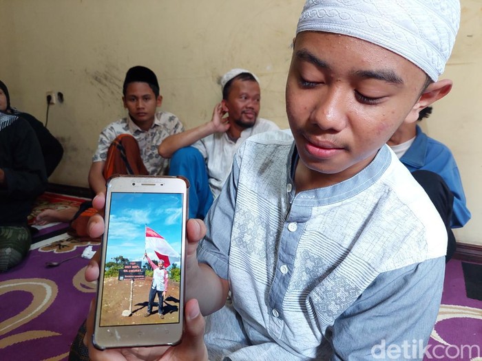 Anak Hardiat Hidayatuloh menunjukkan foto ayahnya saat mendaki gunung.