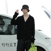 Devil wears Prada? Berbalut busana serba hitam, Jaehyun dari NCT 127 memberi kejutan dengan handbag Prada berwarna shocking green saat hendak meninggalkan Seoul untuk Milan Fashion Week, Kamis (17/6/2022). (Foto: GC Images/Han Myung-Gu)