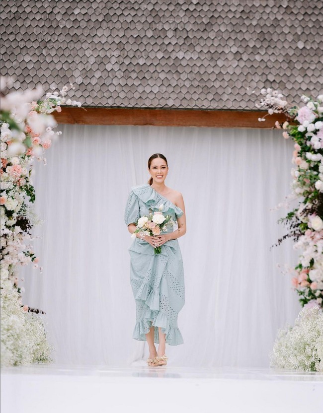 Cathy Sharon tampil feminin mengenakan gaun berpotongan one-shoulder serta detail ruffle pada bagian dada dan hem bawah. Foto: Instagram/@charlottextie