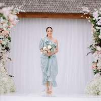 Cathy Sharon tampil feminin mengenakan gaun berpotongan one-shoulder serta detail ruffle pada bagian dada dan hem bawah. Foto: Instagram/@charlottextie