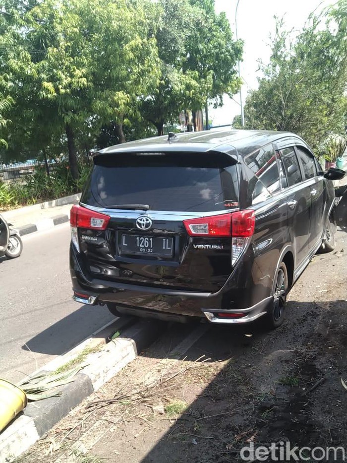 mobil nangkring di tengah pembatas jalan