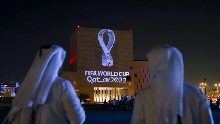 TOPSHOT - Qataris gather at the capital Dohas traditional Souq Waqif market as the official logo of the FIFA World Cup Qatar 2022 is projected on the front of a building on September 3, 2019. (Photo by - / AFP)        (Photo credit should read -/AFP via Getty Images)