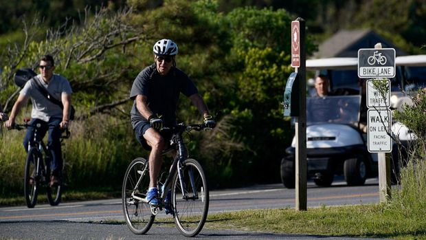 Presiden AS Joe Biden mengendarai sepeda di Pantai Rehoboth, Delaware, AS, Sabtu (18/6/2022). (REUTERS/Elizabeth Frantz)