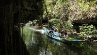 Sejumlah wisatawan menyusuri Sungai Pute dengan menggunakan perahu di kawasan Pegunungan Karst Rammang-Rammang di Kabupaten Maros, Sulawesi Selatan, Minggu (19/6/2022).