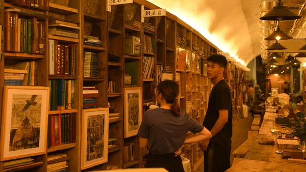 Tampak dua orang pengunjung melihat beragam buku yang tersusun rapi di toko buku unik tersebut.