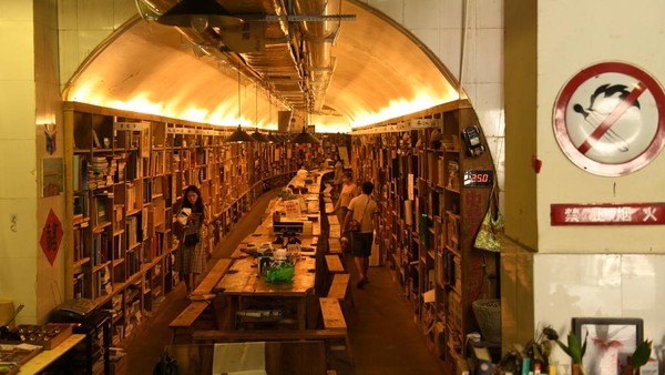 Sejumlah pengunjung melihat beragam buku yang tersusun rapi di sebuah toko buku unik di kawasan Chongqing, China, Selasa (14/6/2022).