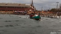 Beberapa pekerja juga tampak berdiri berjajar di tanggul yang berbatasan dengan laut untuk menunggu kapal nelayan. Mereka menumpang kapal nelayan dan turun di Tambaklorok. Foto Angling Adhitya Purbaya/detikJateng.