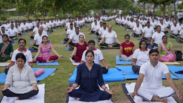 India's paramilitary Rapid Action Force personnel and their family members practise yoga on the eve of International Yoga Day in Ahmedabad, India, Monday, June 20, 2022. (AP Photo/Ajit Solanki)
