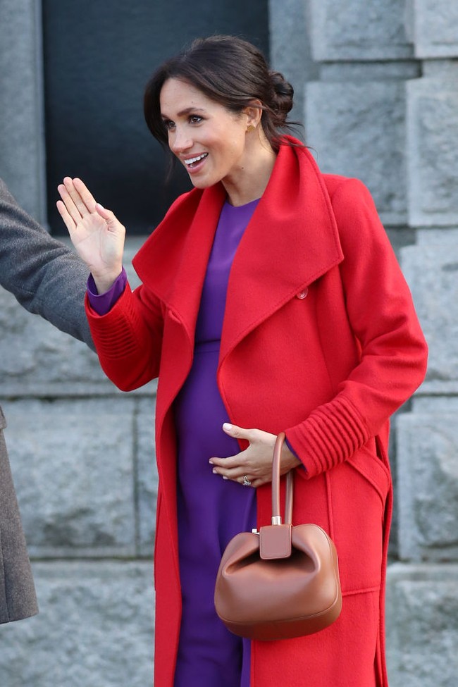 Hamil anak pertama, Meghan Markle tampil stylish dengan gaya ‘tabrak warna’ perpaduan coat merah dan gaun lavender. Saat itu dia tampil cerah penuh warna dalam kunjungan ke Hamilton Square pada Januari 2019 di Birkenhead, Inggris. Foto: Getty Images/Neil Mockford/GC