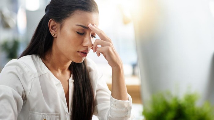 Ilustrasi pasangan yang sedang bertengkar. Shot of a young woman experiencing a headache in the office