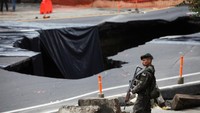 Aparat keamanan bersenjata lengkap dikerahkan untuk menjaga area di dekat sinkhole.