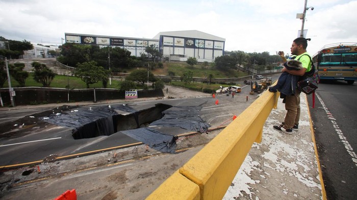 Kala Sinkhole di Tengah Jalan Guatemala Jadi Objek Foto Warga Sebuah lubang raksasa (sinkhole) terlihat di tengah ruas jalan di kawasan Guatemala. Kondisi jalan yang berlubang itu pun jadi sasaran objek foto warga.