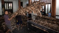 Seorang pria memuat pelepah kelapa kering ke truk sebelum perang obor tahunan digelar di Jepara, Jawa Tengah, Senin (20/6/2022).  