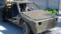 Seorang prajurit Ukraina menjajal mobil reli yang telah dimodifikasi menjadi kendaraan perang di sebuah bengkel di Zaporizhzhia.