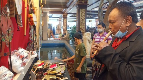 Pengunjung tampak antusias mencoba berbagai alat musik yang ditampilkan di stand Manik Suling dan Putri Ayu pada Minggu (19/6/2022) di Art Center Denpasar, Bali.