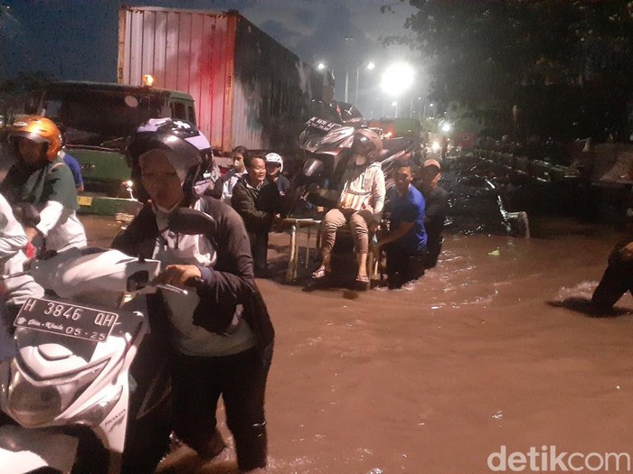 Perjuangan para pekerja tembus banjir di Pelabuhan Tanjung Emas Semarang, Senin (20/6/2022).