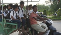 Puluhan bocah sekolah dasar naik angkutan umum modifikasi di luar kota Phnom Penh, Kamboja, Senin (20/6).